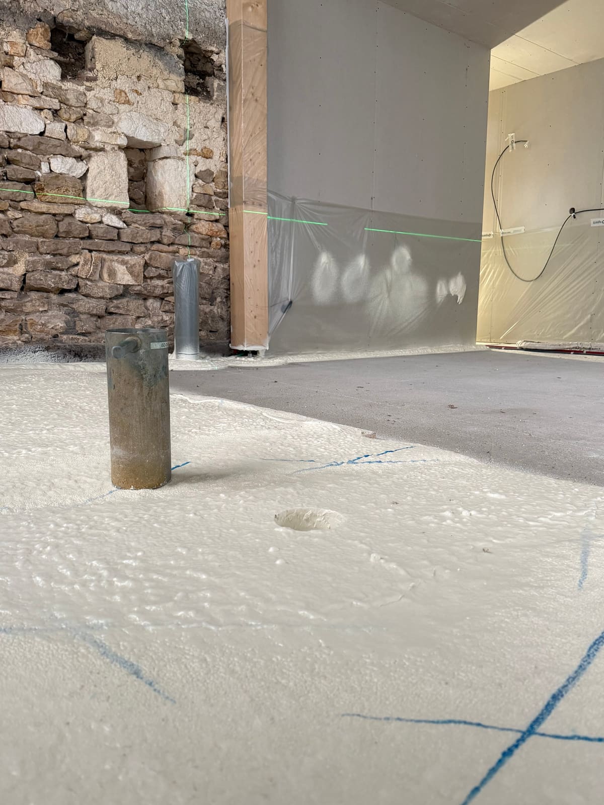 Détail de la projection polyuréthane sur mur en pierre apparente — buse de projection en gros plan · Isolatech